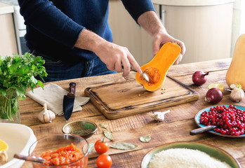 Man cooking healthy food of pumpkin on wooden table