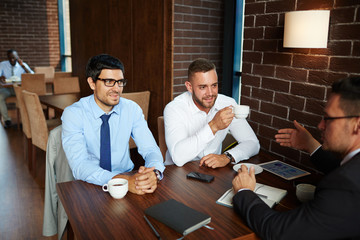 Poster - Confident businessmen listening to explanation of their leader in cafe