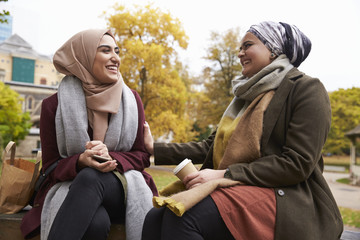 Two British Muslim Women Eating Lunch In Park Together