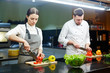 © pressmaster - Young man and woman cutting vegetables in the kitchen