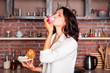 © innatyshchenko - Young woman on the kitchen enjoying eating delicious cake