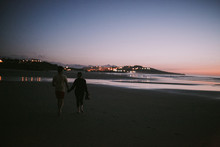 Couple Holding Hands On The Beach With Sunset