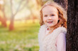 © mashiki - spring portrait of beautiful child girl with curly long hair walking outdoor in blooming garden