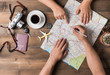 Young couple planning  vacation trip with map. Top view.