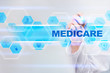 © WrightStudio - Medical doctor drawing medicare on the virtual screen.