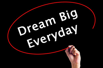 Hand Writing Dream Big Everyday with a marker over transparent board.