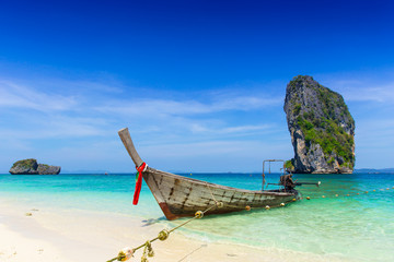 Thailand summer travel sea, Thai old wood boat at sea beach Krabi Phi Phi Island Phuket park on white sand blue sky emerald green ocean water.