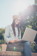 Poster - Portrait of beautiful hipster woman  chatting on laptop in the park