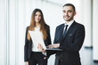 © F8  \ Suport Ukraine - Young and confident businessman with laptop standing in front of business woman