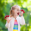 © famveldman - Child picking and eating raspberry in summer