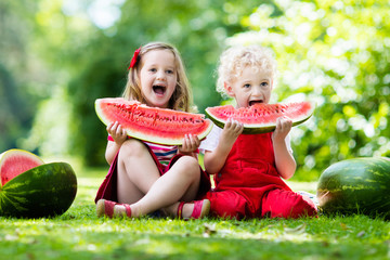 Kids eating watermelon in the garden