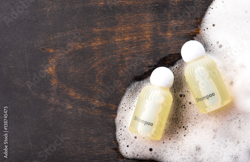 Fotografie, Obraz Shampoo bottle with soap on wood,top view