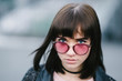 © bodnarphoto - outdoor portrait of a young and very beautiful brunette with big blue eyes in a pink glasses on the blurred background