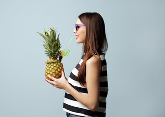 Poster - Young beautiful woman with cocktail in pineapple on light background