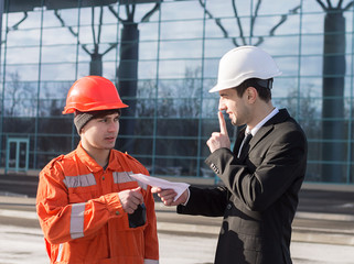 boss or Chief giving a bribe or illegal inoficcial salary in an envelope and smiling. cash in hand.  Boss showing silence sign. Business modern background.