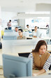 © pressmaster - Separate workplace cubicles with different people sitting at them in open space of modern office