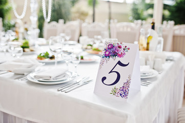 Number five at table for guests on wedding hall.