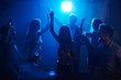 © pressmaster - Group of young people dancing in night club with raised hands holding glasses of champagne