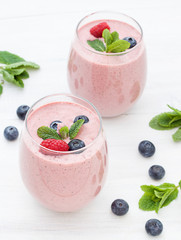 Stylish glasses of healthy smoothies with raspberry and blueberry. Morning breakfast for two. 