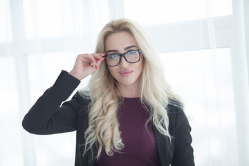 blonde business woman in glasses. confident business woman stands in the office