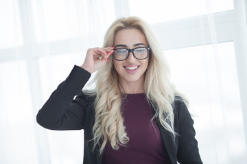 blonde business woman in glasses. confident business woman stands in the office