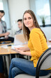 © W PRODUCTION - portrait of young woman in casual wear working in a creative business startup company office with coworker people in background