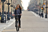 Fototapeta Miasto - Young woman on a bicycle. Ul. Piotrkowska, Łodź, Polska.	