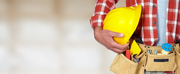 Construction worker with helmet and tool belt.