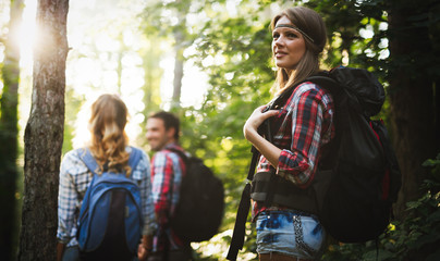 Wall Mural - beautiful woman and friends hiking in forest