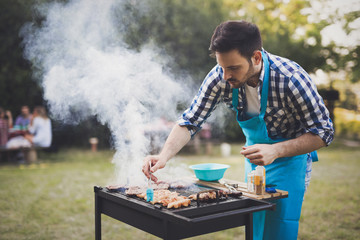 Wall Mural - Handsome man preparing barbecue