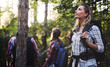 © NDABCREATIVITY - Beautiful woman and friends hiking in forest