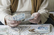 © berna_namoglu - Wrinkled hands counting Turkish Lira banknotes
