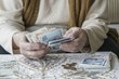 © berna_namoglu - Wrinkled hands counting Turkish Lira banknotes