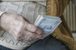 © berna_namoglu - Wrinkled hand holding Turkish Lira banknotes