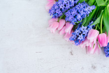 Pink Tulips And Blue Hyacinths Flowers On White Wooden Table