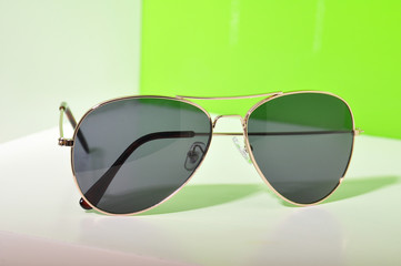 Wall Mural - Sunglasses on white and green background