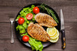 Grilled chicken breast fillet served with herbs, vegetables and