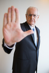 Serious senior businessman showing stop gesture