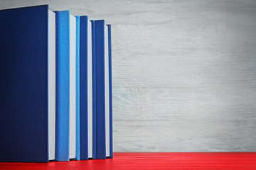 Wall Mural - Books in a row on red wooden table