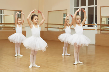 Group of beautiful little girls practicing ballet at class