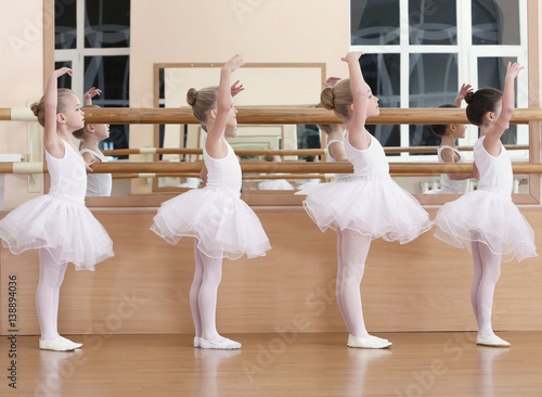 Leinwand Poster  Group of beautiful little girls practicing ballet at class