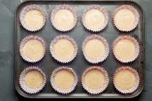 Muffin Cups With Cake Batter In Baking Tray