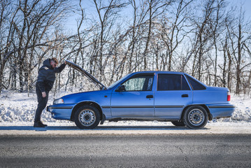 Wall Mural - man repairing a car standing at the hood