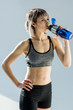 © LIGHTFIELD STUDIOS - portrait of sporty woman drinking water from bottle after training