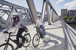 © Westend61 - Germany, Hamburg, couple riding electric bicycles on a bridge