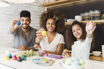 Happy African American family coloring Easter eggs