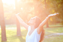 Beautiful Young Woman In Park With Her Arms Outstretched.