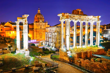 View of the roman ruins at night in Rome, Italy.