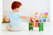 © Olesia Bilkei - cute infant baby playing with wooden hammer block toy