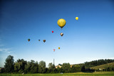 Fototapeta Tęcza - Start of big hot air balloons at the field with cool cloudy sky